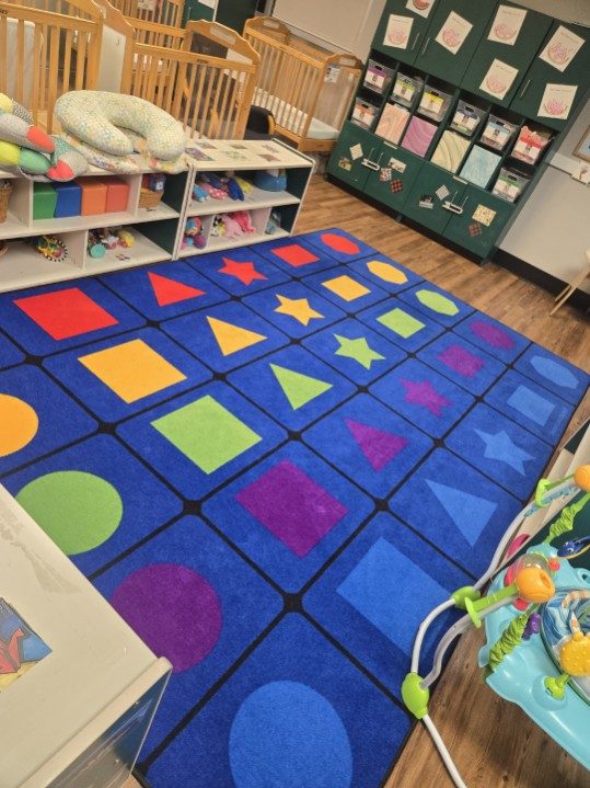 Daycare infant room with cleaned floors and sanitized play rug